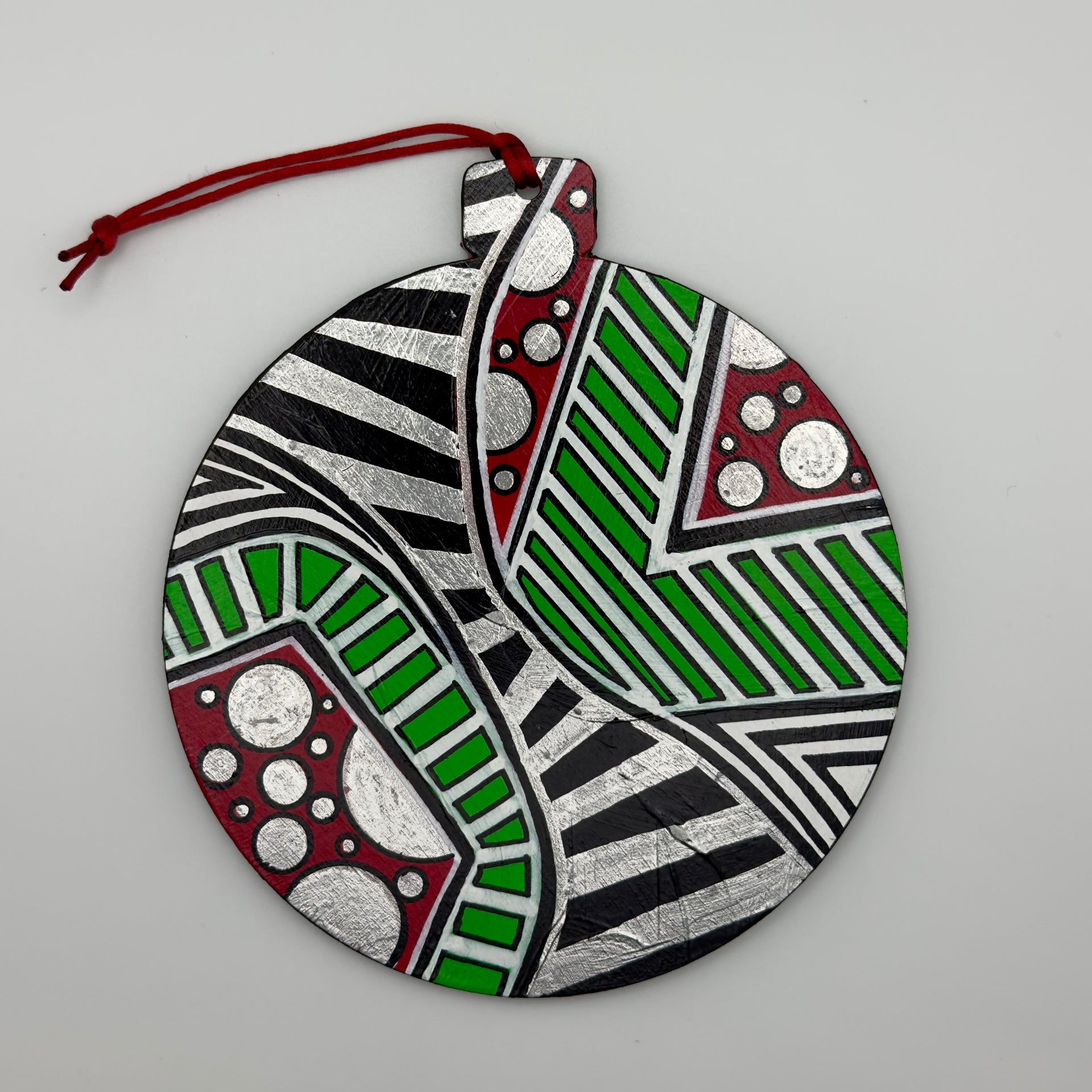 Hand-painted 4.25-inch ornament by Mary-Jo Lough featuring bold colors and intricate patterns, adding a unique touch to holiday decor.