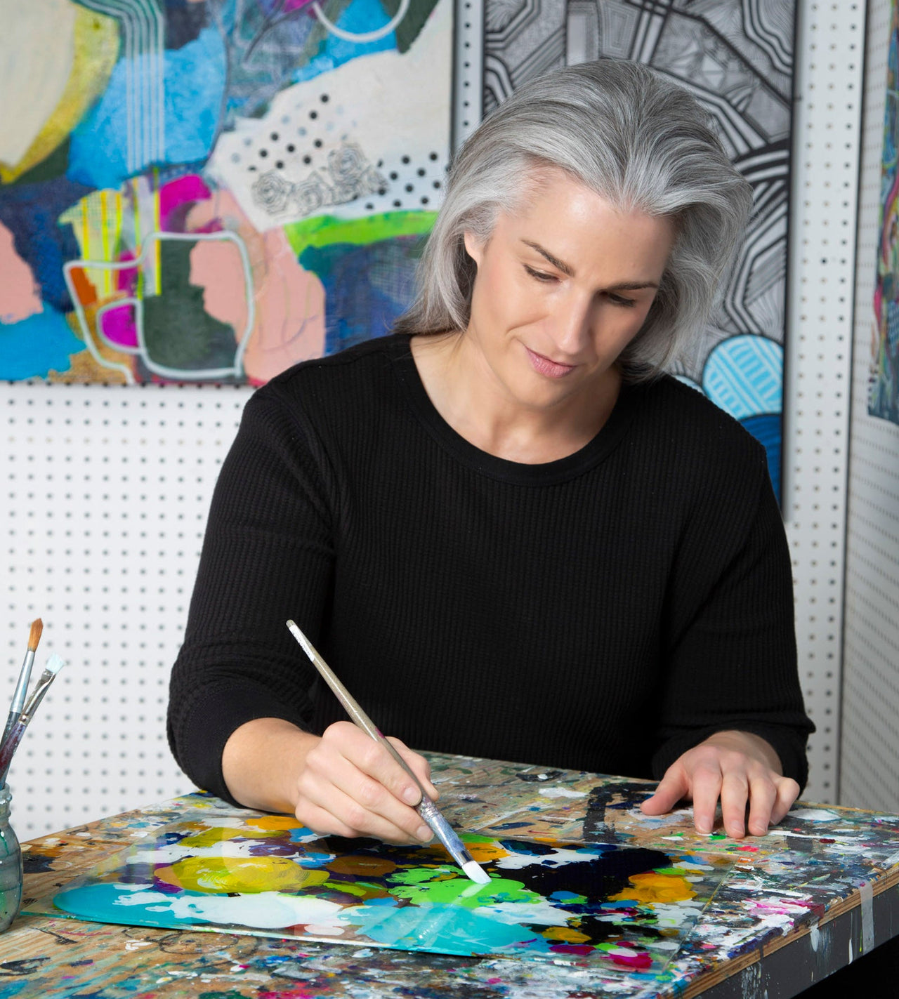 photo of local Calgary abstract artist Mary-Jo mixing paint on her palete 